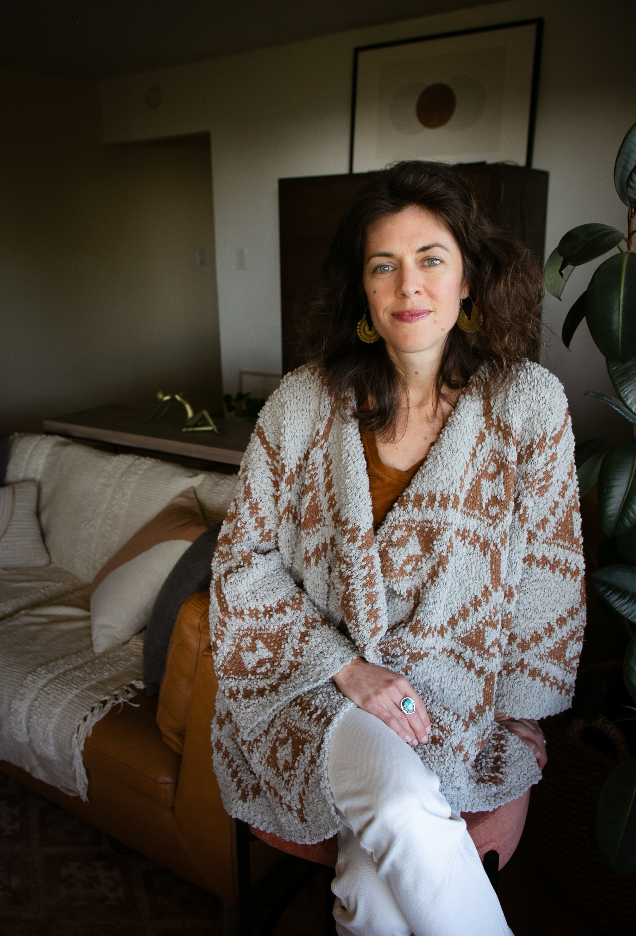 Portrait of Katie Schmidt, MA, a somatic therapist based in Oakland, seated outdoors in natural light