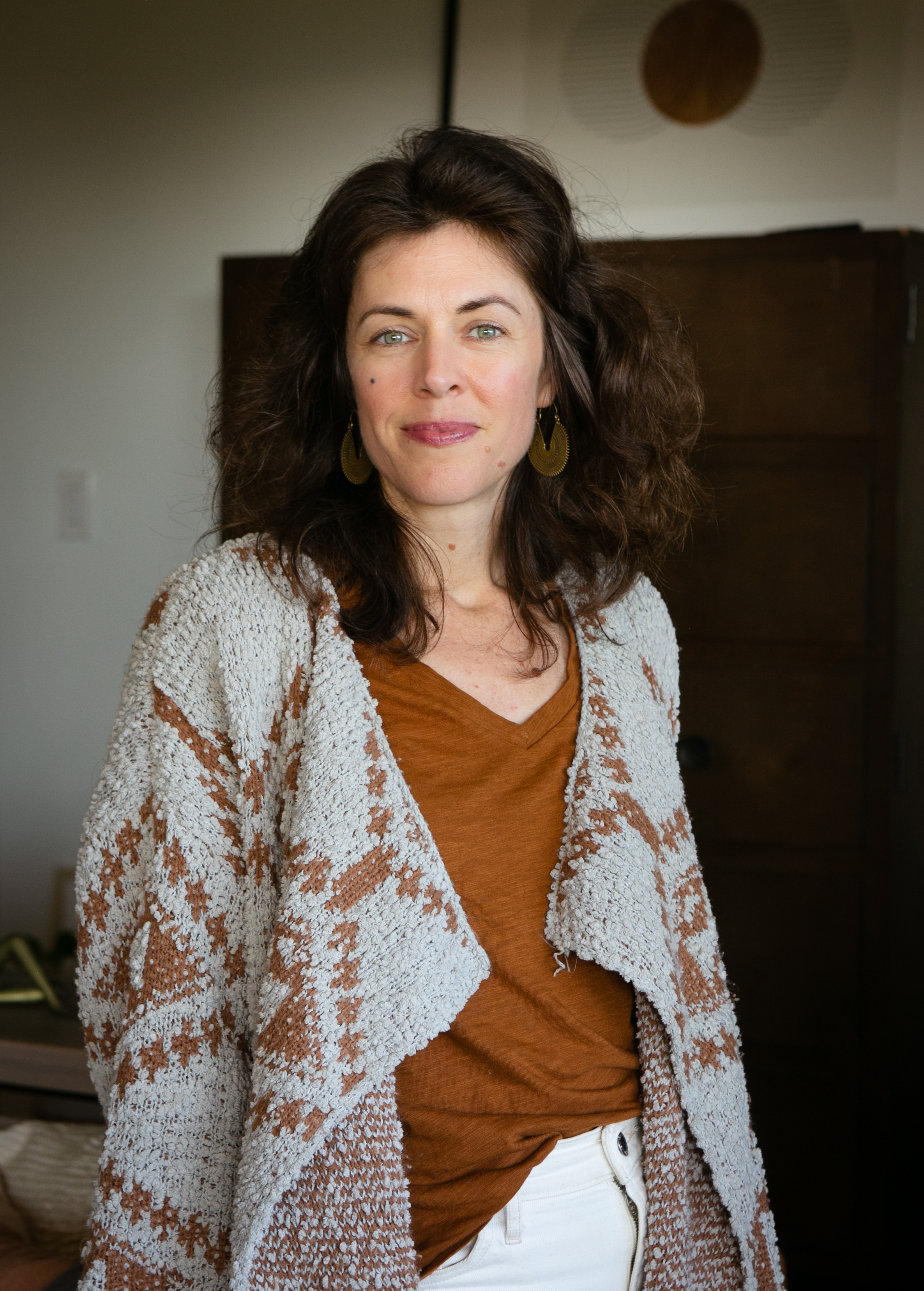 Katie Schmidt, MA, a somatic therapist in Oakland, standing in soft indoor daylight