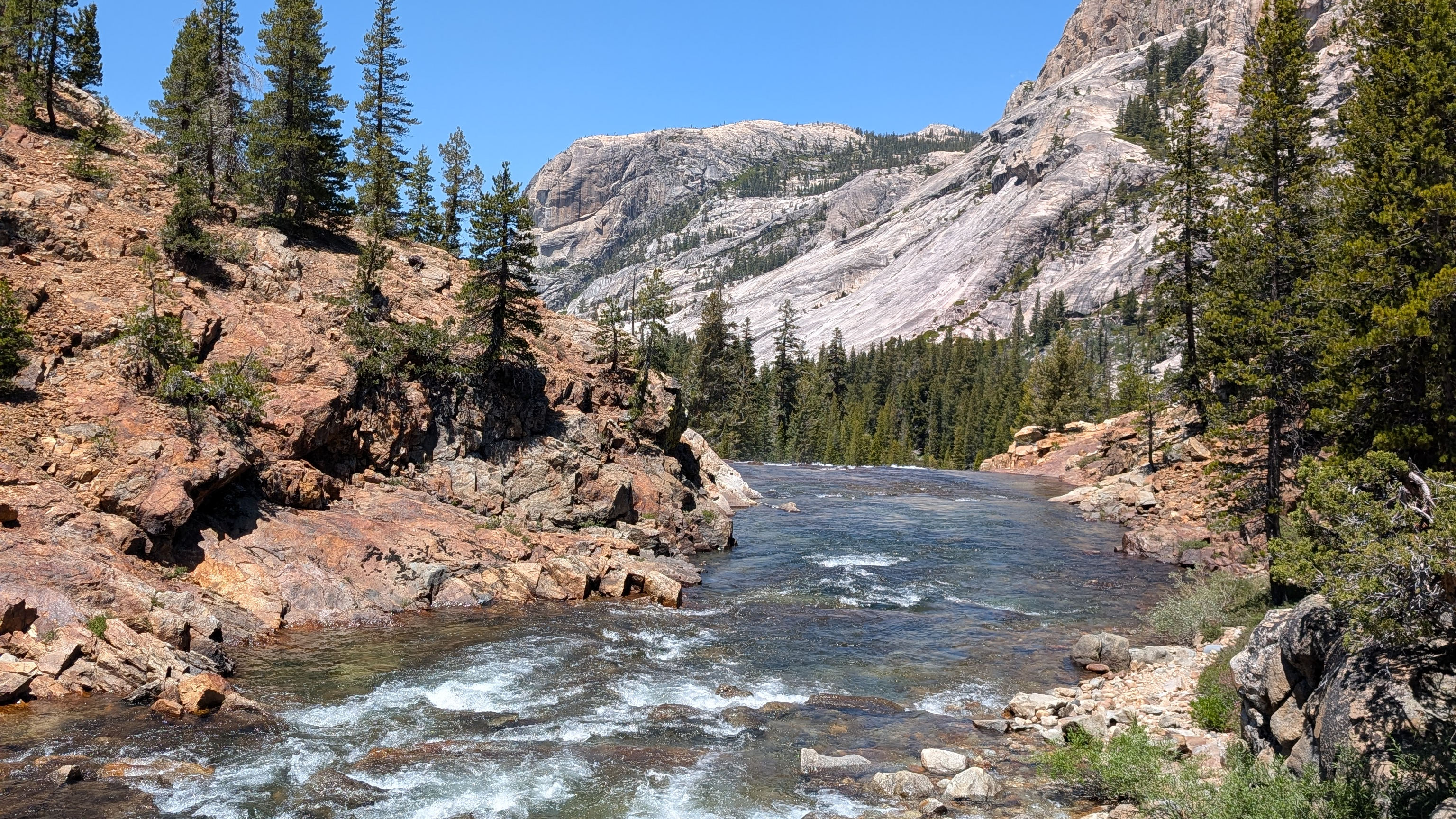 A wide mountain river valley in Yosemite, open sky above bare granite